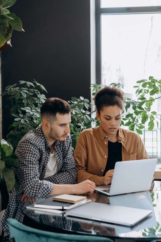 man and woman in front of laptop